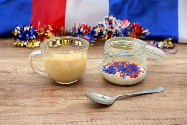 Vanilla cake with red, white, and blue sprinkles and frosting layered in a glass jar